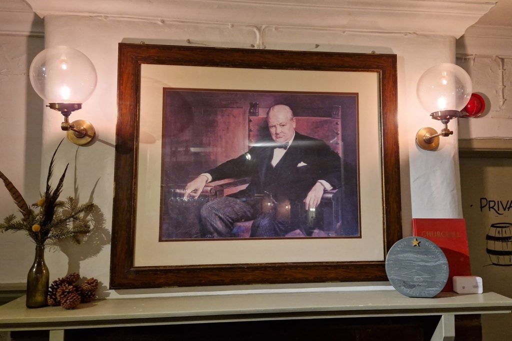 Pictctyre of Winston Churchil over the fireplace in the White House Pub